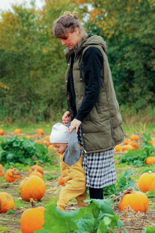 mom and son on a field of pumpkin